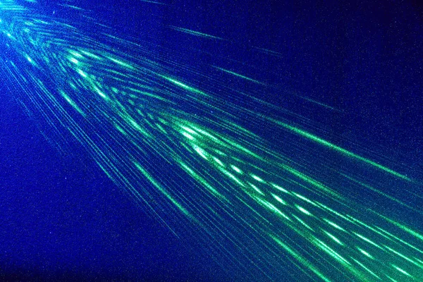 青のグラデーションの背景に 緑の間欠光とパターン化された光の光線 — ストック写真