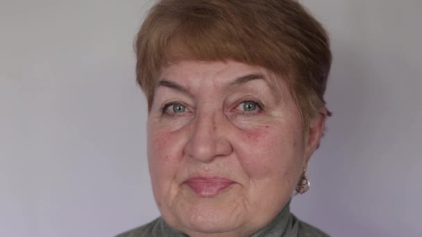 Åldrad Kvinna Tittar Kameran Ljus Bakgrund — Stockvideo