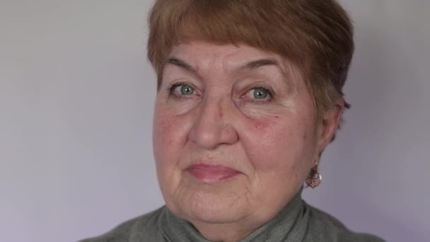 Пожилая Женщина Смотрит Камеру Светлом Фоне — стоковое видео