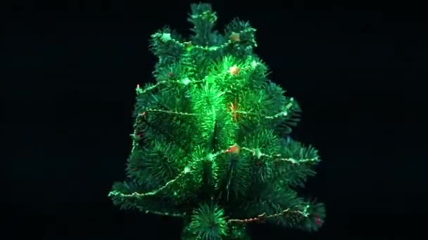 黒い背景に点滅する光のハイライトが点滅する緑の装飾されたクリスマスツリー — ストック動画