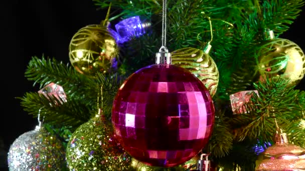 Dunkelrosa Weihnachtskugel Dreht Sich Vor Dem Hintergrund Von Weihnachtsbaumzweigen Die — Stockvideo