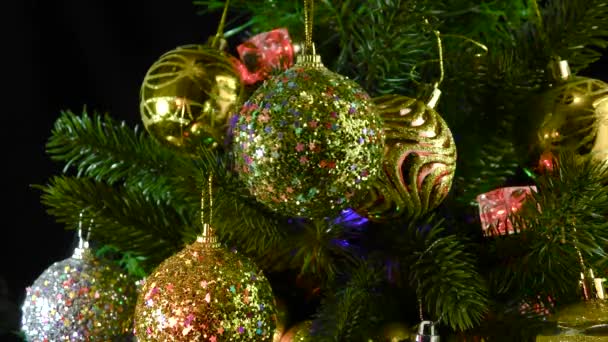 Goldene Weihnachtskugel Dreht Sich Vor Dem Hintergrund Von Christbaumzweigen Die — Stockvideo