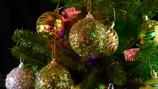 Eine Goldene Weihnachtskugel Dreht Sich Vor Dem Hintergrund Von Weihnachtsbaumzweigen — Stockvideo