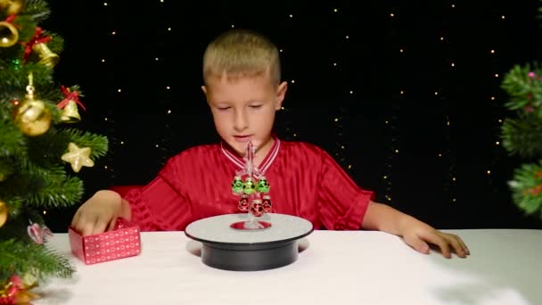 Netter Junge Schmückt Kleinen Weihnachtsbaum Mit Spielzeug — Stockvideo