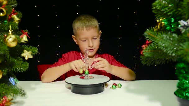 Umgeben Von Großen Weihnachtsbäumen Hängt Ein Süßer Junge Dekorationen Einen — Stockvideo