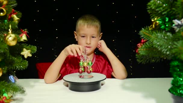 Černém Pozadí Blikajícími Světly Roztomilý Chlapec Zdobí Malý Vánoční Stromeček — Stock video
