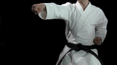 Siyah arka planda, bir yetişkin ve küçük bir atlet yumruk atıyor.