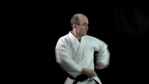 Fekete Alapon Egy Felnőtt Sportoló Formális Karate Gyakorlatokat Végez — Stock videók