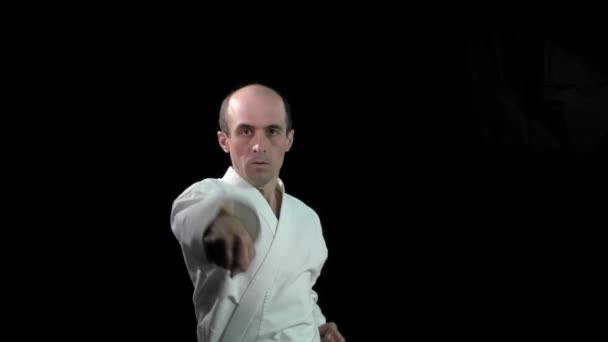 Een Zwarte Achtergrond Een Volwassen Atleet Voert Formele Karate Oefeningen — Stockvideo
