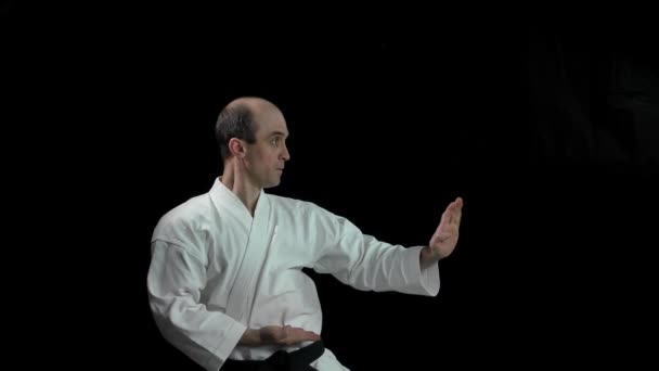 Een Zwarte Achtergrond Een Volwassen Atleet Voert Formele Karate Oefeningen — Stockvideo