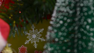 Noel Baba 'nın, çam kozalaklarıyla süslenmiş bir Noel ağacının yanında yakın çekimi.
