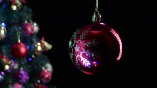 Auf Schwarzem Hintergrund Dreht Sich Eine Rote Weihnachtskugel Mit Schneeflockenmuster — Stockvideo