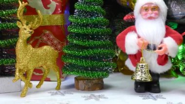 Küçük Noel ağaçları ve hediyelerle çevrili Noel heykelcikleri