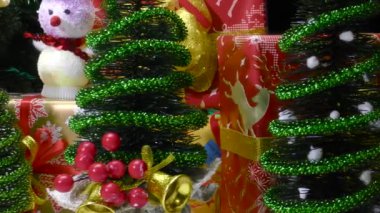 Küçük Noel Baba küçük Noel ağaçları ve hediyelerle çevrili.