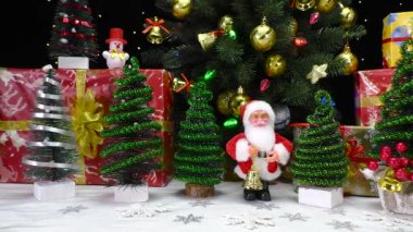 Noel Baba 'nın küçük Noel ağaçları ve büyük bir Noel ağacının yanında hediyelerle çevrili olduğu yakın plan.