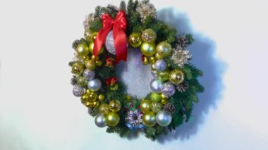 Noel 'de büyük bir Noel çelengi beyaz arka planda toplar ve çanlar ile süslenir.