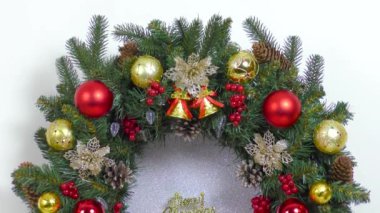 Yanan iki mumun arkasında hareketli bir Noel çelengi büyük güzel bir Noel çelengidir.