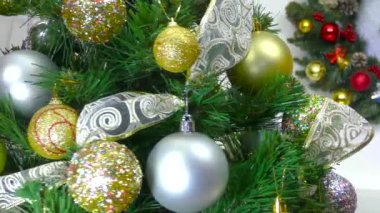 Noel ağacını yakın çekimde Noel çelengi önünde Noel topları dönüyor