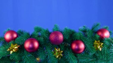 Kırmızı Noel baloları ve süslemeler mavi arka planda Noel ağacı dalları