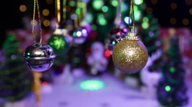 Yeni yılın renkli süslemeleri yanıp sönen animasyonla yarı bulanık bir Noel arka planında sallanıyor.