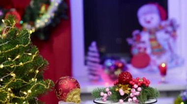 Noel arkaplanında, yeni yıl balosunda, küçük bir Noel ağacı ve dekorasyonlu dönen bir stantta.