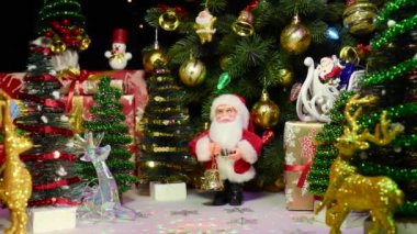 Noel zamanı Noel Baba heykelciğinin Noel Baba 'nın kızağındaki hediyelerinin yakınında.