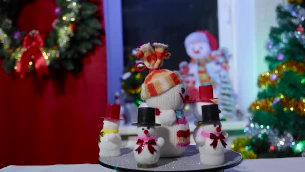 在圣诞节的背景下 一个大雪人和几个小雪人轮流站在看台上 — 图库视频影像