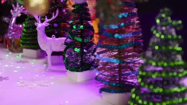 Vánoce Pohybu Detailní Záběr Sněhuláka Mezi Malými Vánočními Stromky Jeleny — Stock video