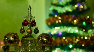 Yarı bulanık bir arka planda, bir Noel ağacı ile küçük bir Noel ağacı sarı toplar arasında döner..