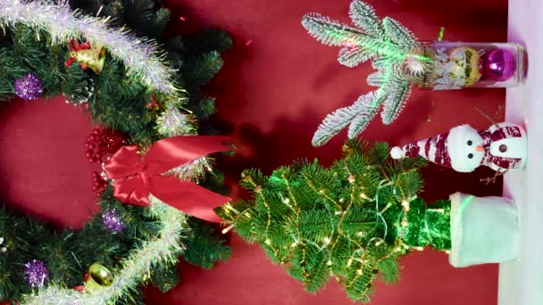 在红色的背景上 有一个圣诞花环 一棵装饰着雪人和圣诞树枝条的圣诞树 — 图库视频影像
