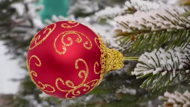 Auf Halbverschwommenem Hintergrund Hängt Eine Rote Weihnachtskugel Mit Mustern Den — Stockvideo