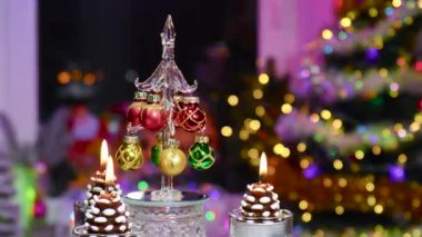 Koni şeklinde mumlarla çevrili bir tezgahta dönen bir Noel ağacının yakın çekimi