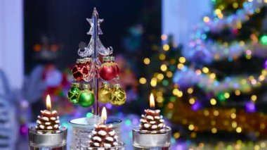 Bir Noel ağacı koni şeklinde yanan mumlarla çevrili bir tezgahta döner.