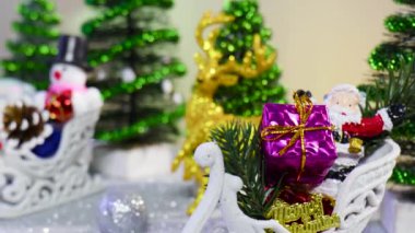 Noel Baba 'nın Noel ağaçlarının ve oyuncakların arasındaki kızakta hediyelerle yakın çekimi.