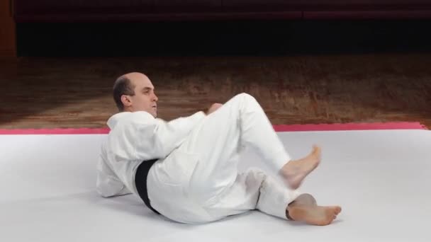 Athlete Black Belt Performs Kicks While Lying Surface Video Clip