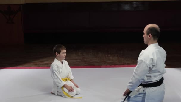 Entrenador Atleta Infantil Haciendo Salto Pie Desde Una Posición Sentada — Vídeo de stock
