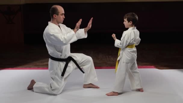一位教练教一位幼儿运动员如何用拳头打手心 — 图库视频影像