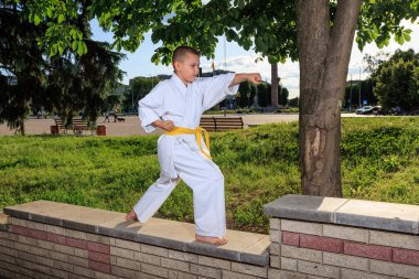 Karategi 'deki erkek sporcu şehir meydanının arka planına elleriyle yumruk atıyor.