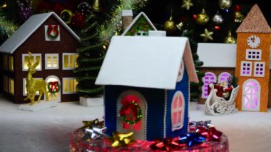 Mavi bir Noel evi, Noel evlerinin arka planında dönüyor.