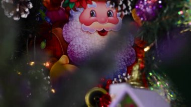 Noel ağacı dalları, Noel Baba 'nın büyük bir görüntüsü karşısında dönüyor.
