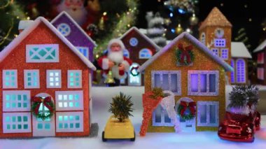 Büyük bir Noel kasabası. Yanında bir şapel, büyük dekore edilmiş evler ve arabalar var.