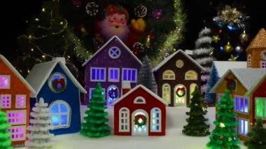 Noel taşınıyor. Renkli evleri olan büyük bir Noel kasabası. Pencereleri ışıklandırılmış Noel ağaçları ve şapeliyle süslenmiş.