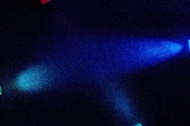 Mavi bir arkaplanda geniş ve dar ışık demetleri üzerinde mavi ve mor renkte.