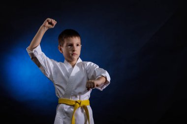 Koyu mavi arka planda, bir erkek sporcu resmi egzersizler yapıyor.