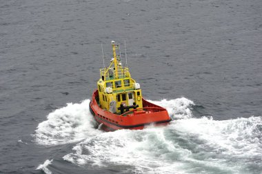 Isafjordur, Westfijords, İzlanda - 3 Haziran 2022: Pilot gemisi Sturla Halldorsson 2642 Gri bir günde beyaz su yaratıyor