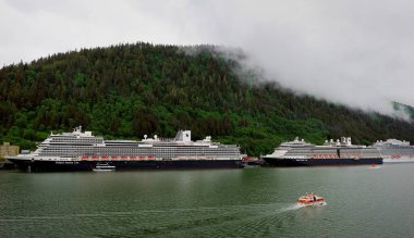 Juneau, Alaska, ABD - 26 Haziran 2023: Hollanda Amerika kardeş gemileri, Koningdam ve Eurodam ve Haziran ayının puslu limanındaki ihaleleri