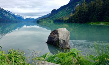 Chilkoot Lake and the snow capped mountain reflections clipart