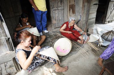 Nha Trang, Vietnam - 23 Nisan 2013: Geleneksel Vietnam hcoolie hasır şapkası yapan aile