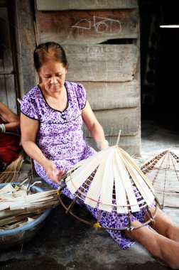 Nha Trang, Vietnam - 23 Nisan 2013: Geleneksel Vietnamlı Hcoolie hasır şapkası yapan kadın