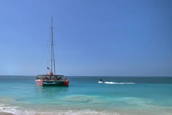 stock image Turners Beach, Antigua - 1st February 2024:Mystic cruises Catamaran and a jet ski at Turners Beach